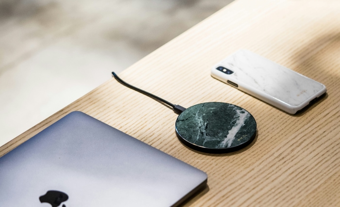 Sleek wireless charging disc on a light wooden table