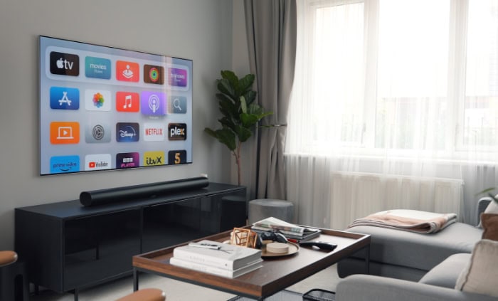 Smart TV displaying app icons in modern living room with soundbar