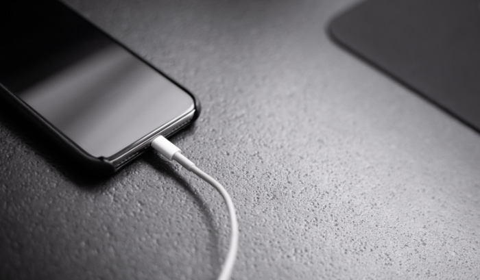 Smartphone charging on black desk