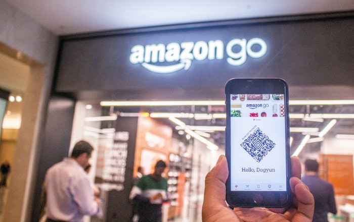 Smartphone displaying Amazon Go QR code at store entrance