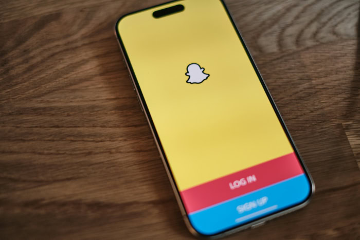 Smartphone displaying Snapchat login screen on wooden table
