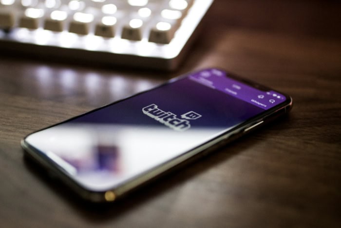 Smartphone displaying Twitch app logo on purple background