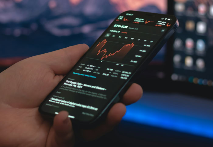 Smartphone displaying cryptocurrency trading chart with market data