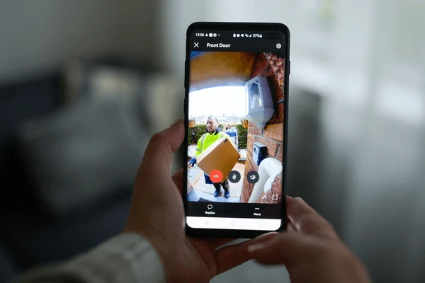 Smartphone displaying live video feed from smart doorbell