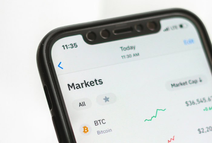 Smartphone showing cryptocurrency markets app with price charts