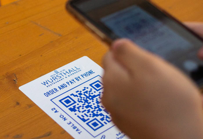 Smartphone user scanning table QR code for payment