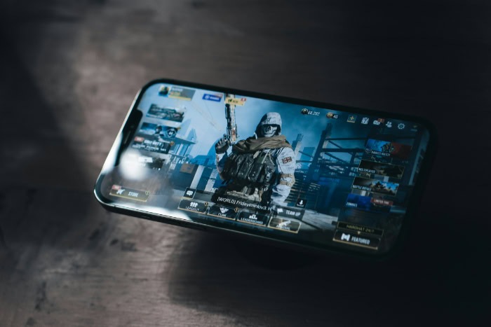 Smartphone with action game on screen showing character menu