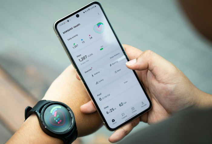 Smartwatch paired with smartphone showing health tracking app