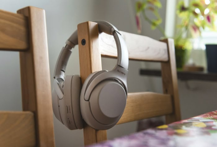 Sony wireless headphones hanging on a wooden chair