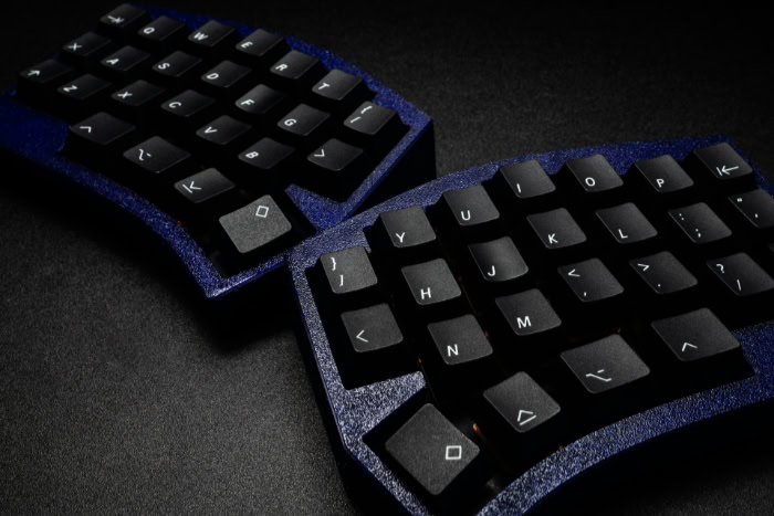 Split keyboard with dark keycaps and blue case