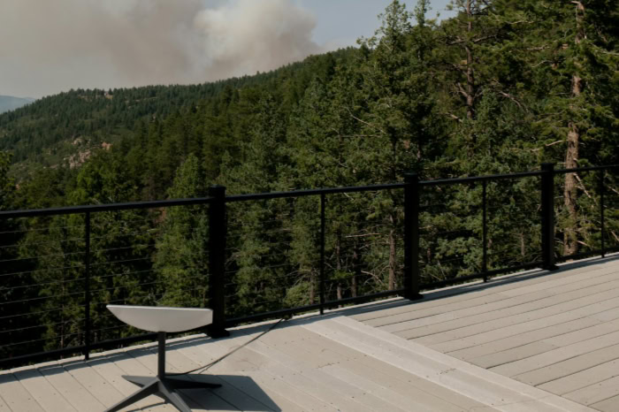 Starlink dish on deck with clouds and trees