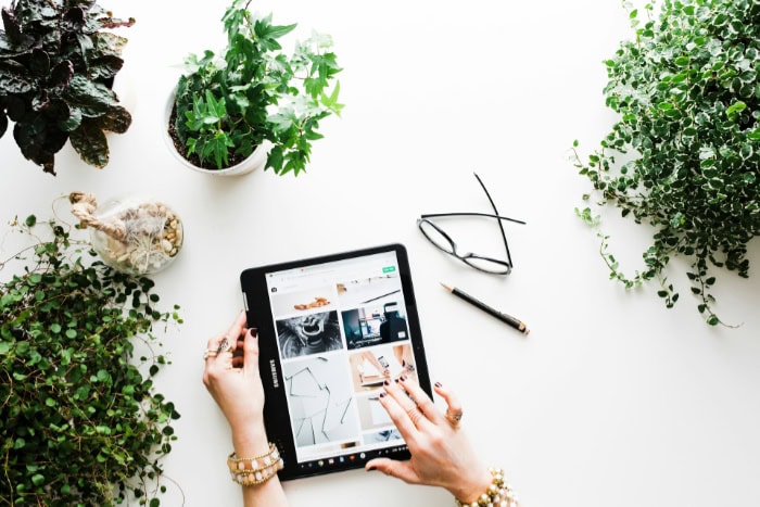 Tablet displaying an online store surrounded by plants