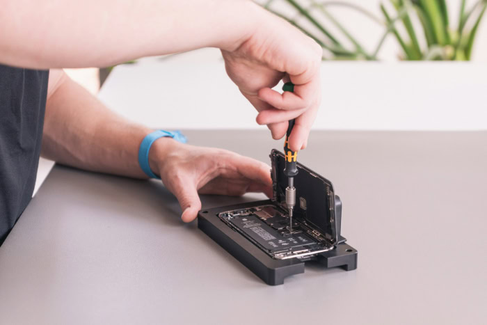 Technician repairing smartphone with a precision screwdriver resized