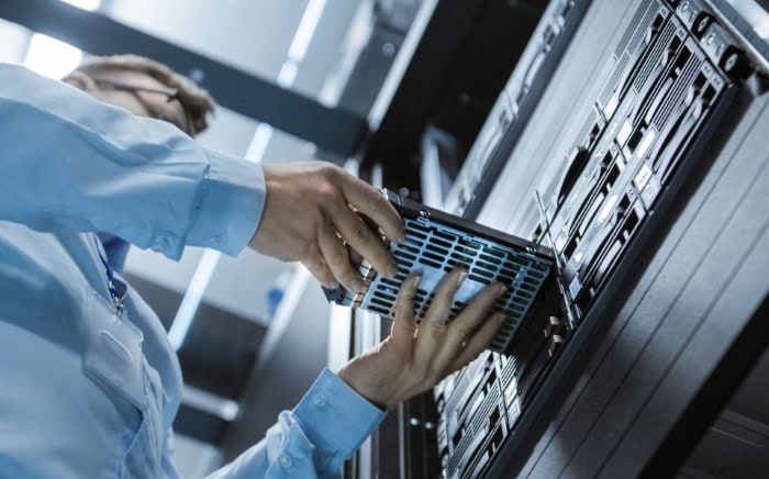 Technician servicing server rack in data center