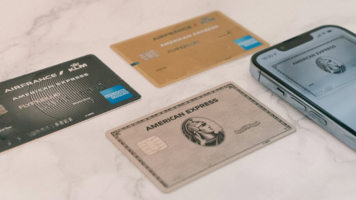 Three American Express cards and phone on table