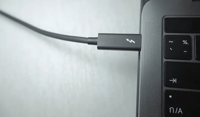 Thunderbolt cable plugged into MacBook laptop port