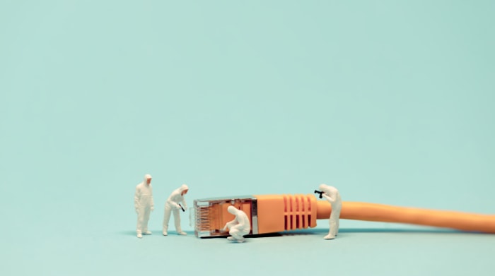 Tiny figures examining an orange Ethernet connector