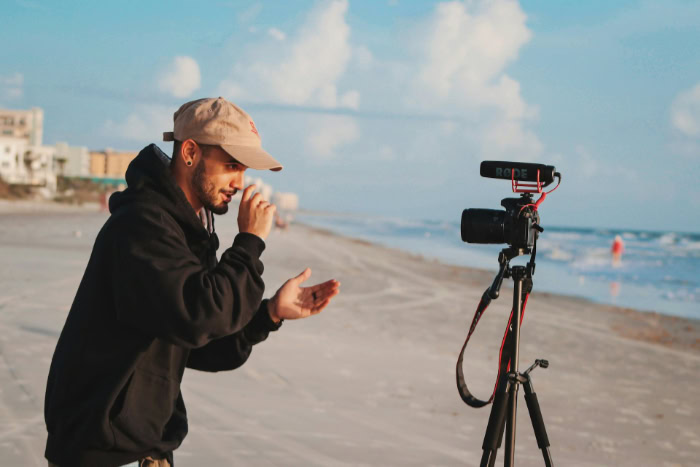 Travel vlogger recording video on the beach