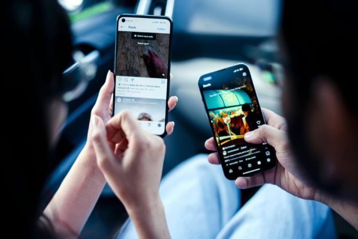 Two people browsing social media on smartphones