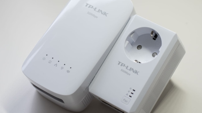 Two white TP Link powerline adapters on a white surface