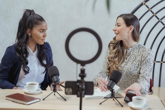 Two women recording a podcast with microphones