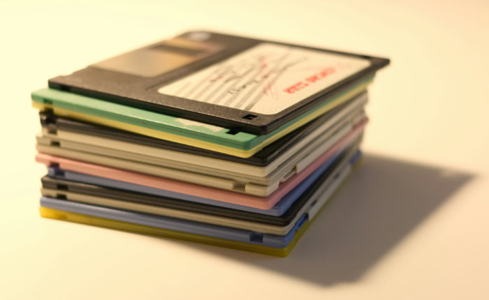 Vertical stack of various colored 3.5 inch floppy disks