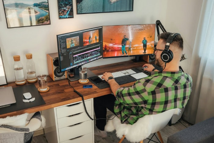 Video editor working on a desktop with a dual monitor setup