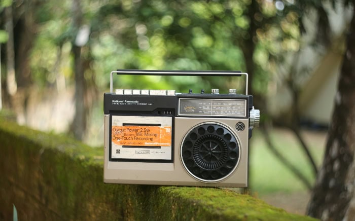 Vintage radio cassette player on mossy forest rock