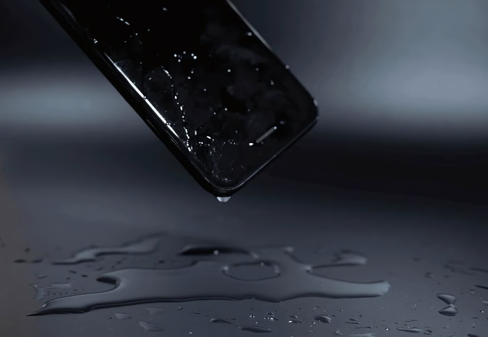 Water droplet falling from wet smartphone corner