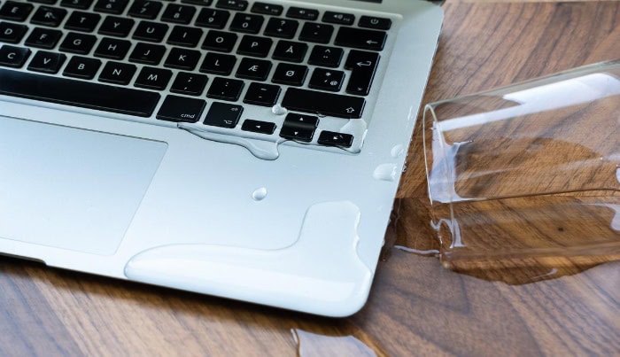 Water spilled on a laptop keyboard and desk