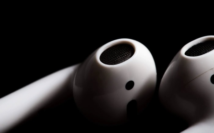 White AirPods earbuds close up on black background