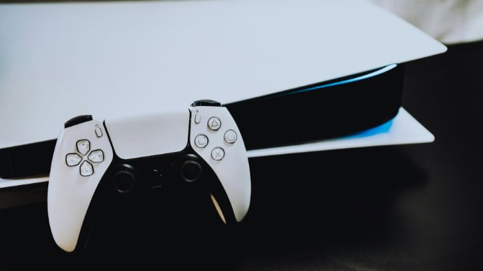 White PS5 console and DualSense controller on a table