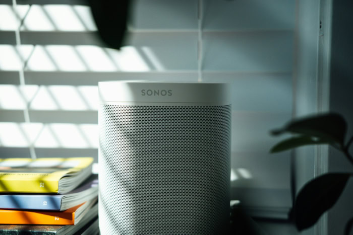 White Sonos wireless smart speaker on a shelf