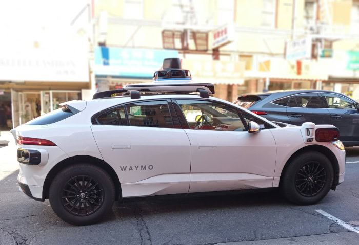 White Waymo autonomous vehicle parked on street