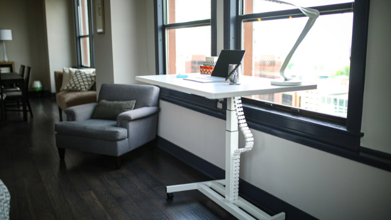 White adjustable standing desk in modern office