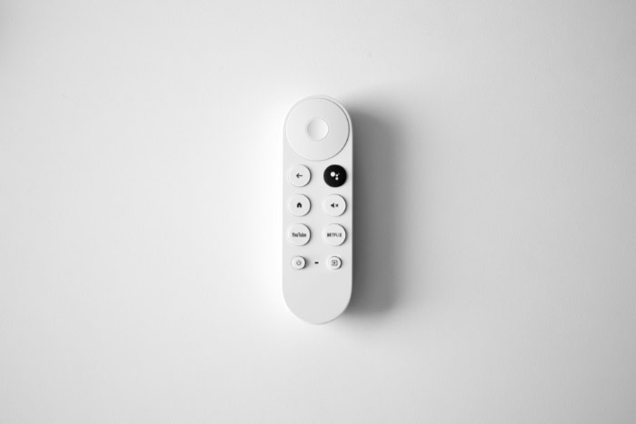 White chromecast remote control with YouTube Netflix buttons