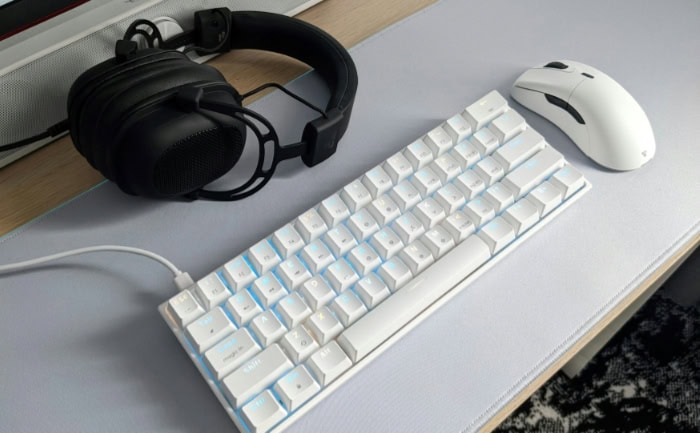 White gaming keyboard mouse and headphones on a desk setup