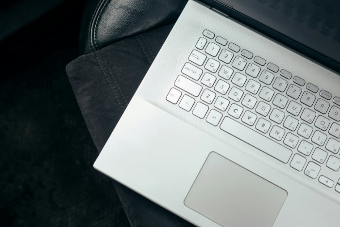 White laptop on black car seat interior
