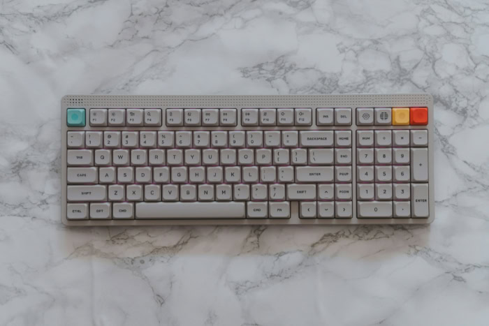 White mechanical keyboard with colorful keys on marble