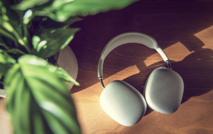 White minimalist wireless headphones on wooden table