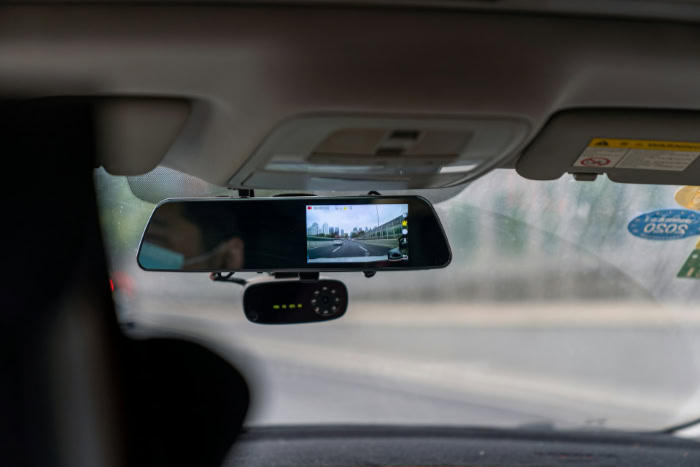 Wide rearview mirror dashcam recording city driving view