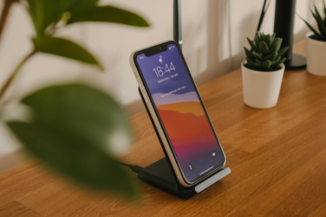 White iPhone wireless charging on wooden table