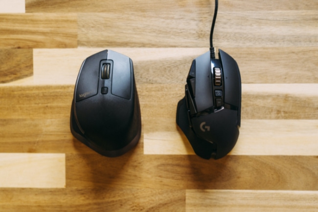 Black Wireless and wired mouse on wooden surface