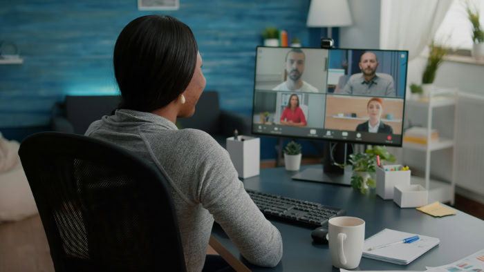 Woman at desktop computer joining group video meeting