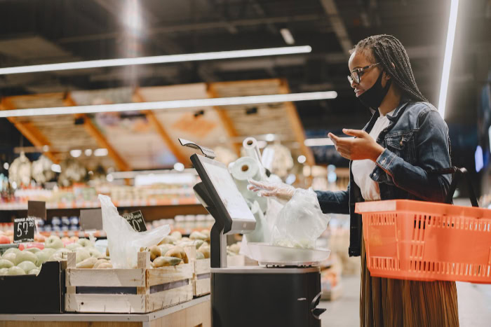 Woman at supermarket self checkout kiosk