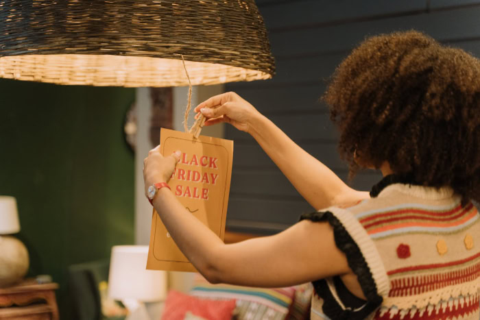 Woman hanging a paper Black Friday sale sign
