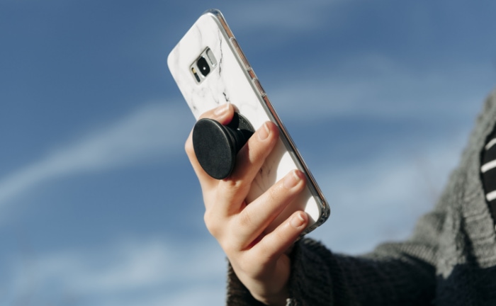 Woman holding phone with popsocket