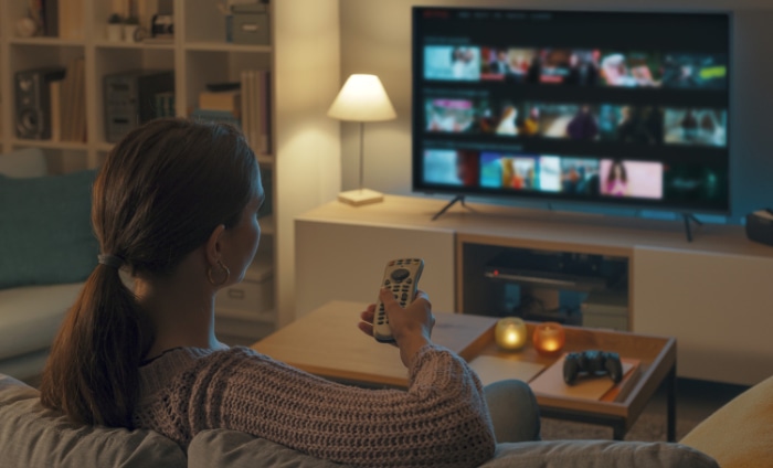 Woman holding smart tvs remote control