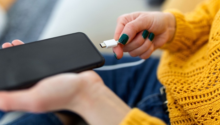 Woman plugging a charger in a smartphone