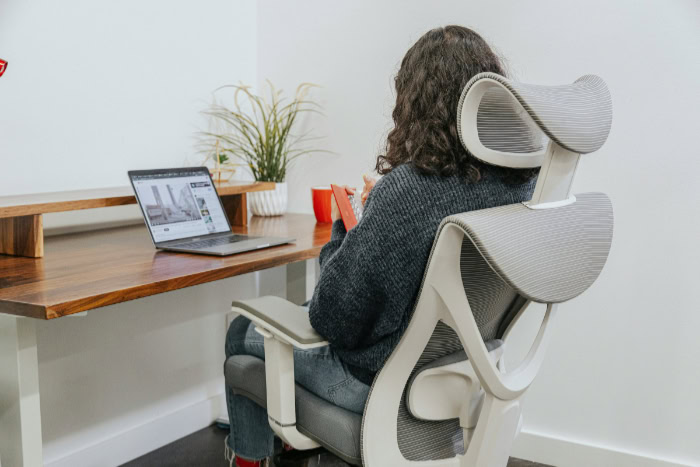 Woman sitting in ergonomic office chair at desk